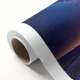 Rolled canvas depicting a serene landscape scene with vibrant green fields under a clear blue sky, elegantly packaged in a protective cardboard tube for easy transport and display.