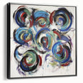 Framed canvas artwork displaying abstract splatters in vibrant colors, set against a sleek black frame, showcasing a modern artistic style ideal for contemporary decor.