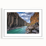Framed landscape artwork showcasing rugged cliffs in vibrant colors, elegantly matted in white for a modern aesthetic, perfect for home decor.