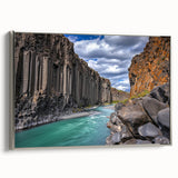 Framed canvas artwork showcasing a dramatic cliff landscape with rich colors and intricate details, accented by a sleek silver frame for modern decor.