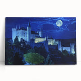 Stretched canvas artwork depicting a picturesque landscape with a medieval castle surrounded by lush greenery and a clear blue sky, ideal for home décor.