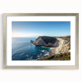 Silver-framed landscape artwork showcasing dramatic cliffs and serene skies, elegantly matted for a polished presentation, perfect for home decor enhancement.