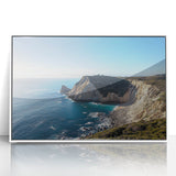 Framed acrylic landscape artwork depicting dramatic cliffs and serene ocean waves, presented in a sleek white frame to enhance any modern decor.