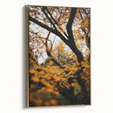 Framed canvas featuring a vintage-style landscape painting of an autumnal scene with muted gold and black tones.