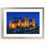 Silver-framed landscape artwork depicting a majestic castle surrounded by lush greenery, elegantly matted for a refined presentation, perfect for home decor.
