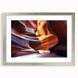 Framed landscape artwork depicting vibrant canyons in rich earth tones, set in a stylish silver frame with matting, ideal for home decor enhancement.