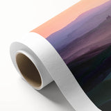 Rolled canvas artwork depicting a vibrant landscape field scene with lush greenery and soft blue skies, carefully packaged in a protective cardboard tube.