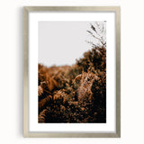 Textured abstract art print in warm autumn hues on a framed silver canvas, ideal for bedroom ambiance.