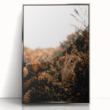 Mid-century modernist art depicting autumn trees in orange and brown tones on a silver-framed acrylic print.