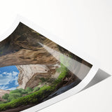 Vibrant rolled landscape print depicting a serene cave scene with rich colors and intricate details, packaged securely in a protective cardboard tube for shipping.