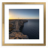 Elegant gold-framed landscape artwork depicting dramatic cliffs and serene ocean waves, accented with a white mat, perfect for enhancing home decor with a touch of nature's beauty.