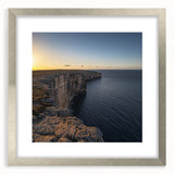 Framed landscape artwork showcasing dramatic cliffs under a vibrant sky, surrounded by a silver mat. Ideal for home decor or office settings, enhancing any space with its natural beauty.
