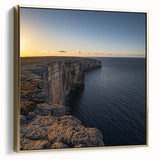 Framed canvas artwork depicting stunning coastal cliffs at sunset, featuring silver and gold tones that enhance the natural beauty of the landscape. This piece adds elegance to any room decor.