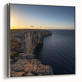 Framed canvas artwork depicting a stunning landscape of cliffs at sunset, featuring vibrant colors and a sleek silver frame, ideal for modern home decor.
