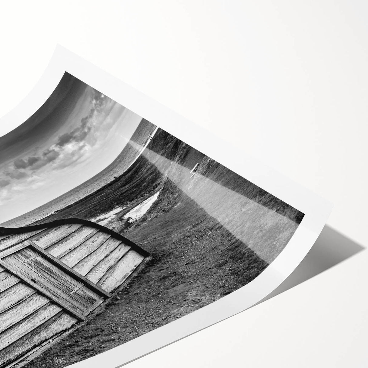 Landscape barn wall art print showcasing a serene rural scene with a rustic barn, vibrant green fields, and a soft blue sky, rolled for easy display.