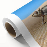 Desert landscape rolled canvas artwork showcasing vibrant hues of orange and yellow under a blue sky, elegantly packaged in a protective cardboard tube for display.