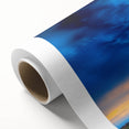 Vibrant rolled canvas print depicting a serene landscape with rolling green fields and a cloudy blue sky, carefully packaged in a protective cardboard tube for shipping.