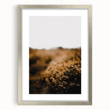 Textured abstract art print depicting autumnal hues in a silver frame, ideal for bedroom ambiance.