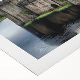 Rolled canvas artwork showcasing a vibrant landscape featuring an enchanting castle surrounded by lush greenery and blue skies, elegantly packaged in a protective tube for easy transport.