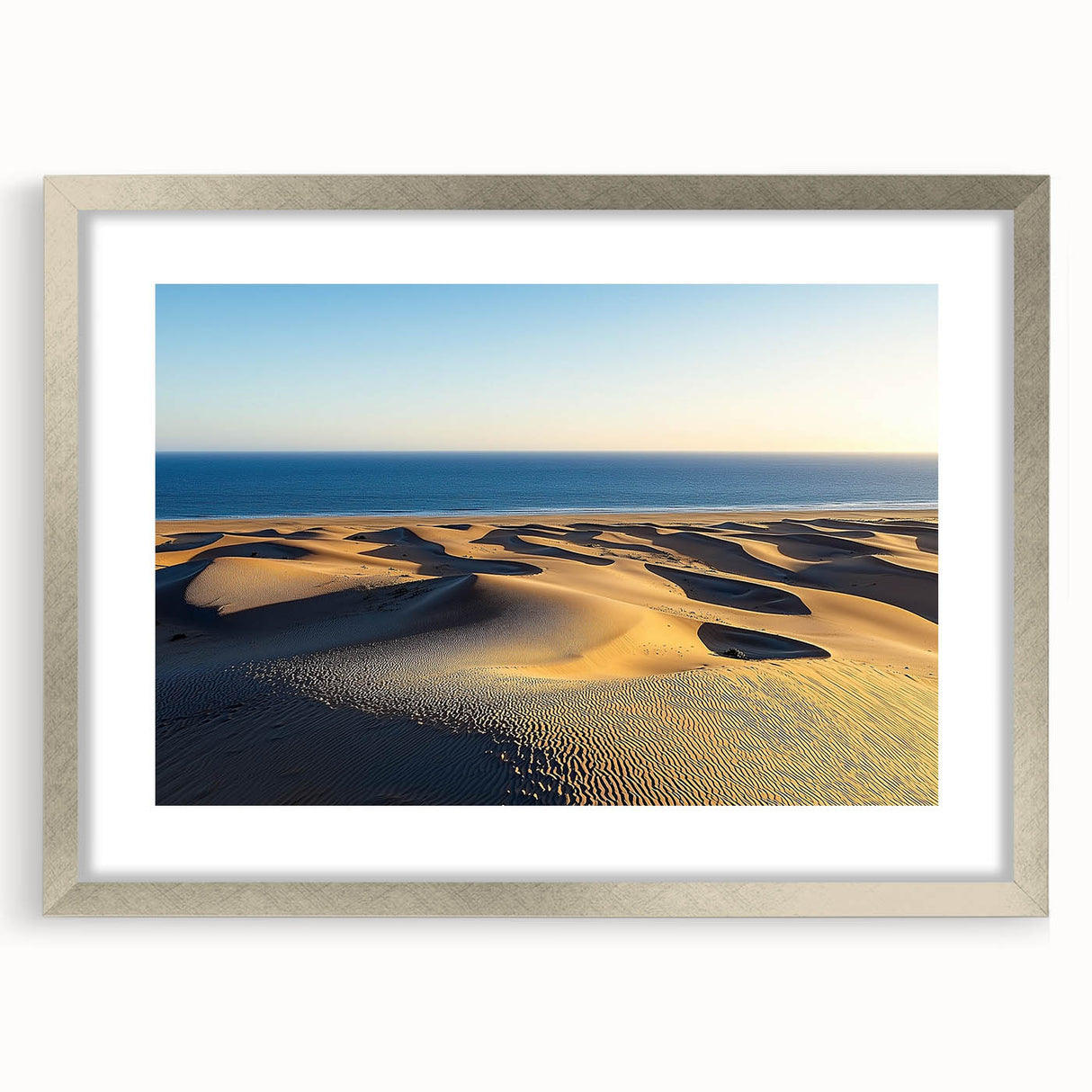 Framed artwork showcasing a serene landscape of rolling dunes, elegantly matted in silver, perfect for modern home decor. Ideal for enhancing living spaces with nature-inspired aesthetics.
