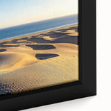 Close-up of a framed canvas artwork depicting serene sand dunes at sunset, showcasing warm golden and beige tones, perfect for enhancing modern home decor.
