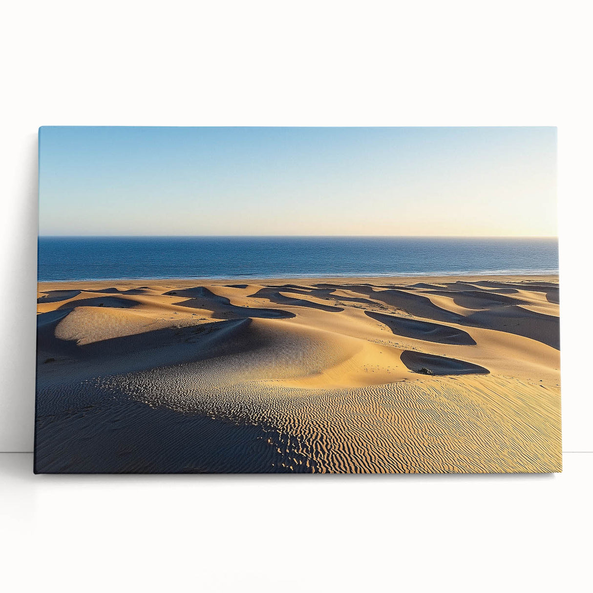 Stretched canvas artwork showcasing a serene desert landscape with rolling dunes, featuring warm tones of beige and soft shadows, perfect for home decor.