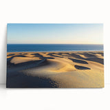 Stretched canvas artwork showcasing a serene desert landscape with rolling dunes, featuring warm tones of beige and soft shadows, perfect for home decor.