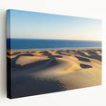 Stretched canvas artwork depicting serene desert dunes at sunset, showcasing warm golden and orange hues, perfect for enhancing modern home decor or art collections.