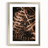 Textured art abstract print in warm orange and red tones on a silver-framed canvas, suitable for bedroom decor.