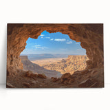 Stretched canvas artwork depicting a vibrant landscape with intricate cave formations, leaning against a neutral wall, ideal for home decor enthusiasts.