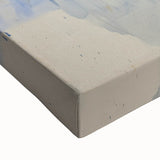 Close-up of an abstract splatter design on stretched canvas, featuring vibrant colors of blue, orange, and yellow, ideal for modern home decor. The textured surface adds depth, enhancing visual appeal in any artistic setting.