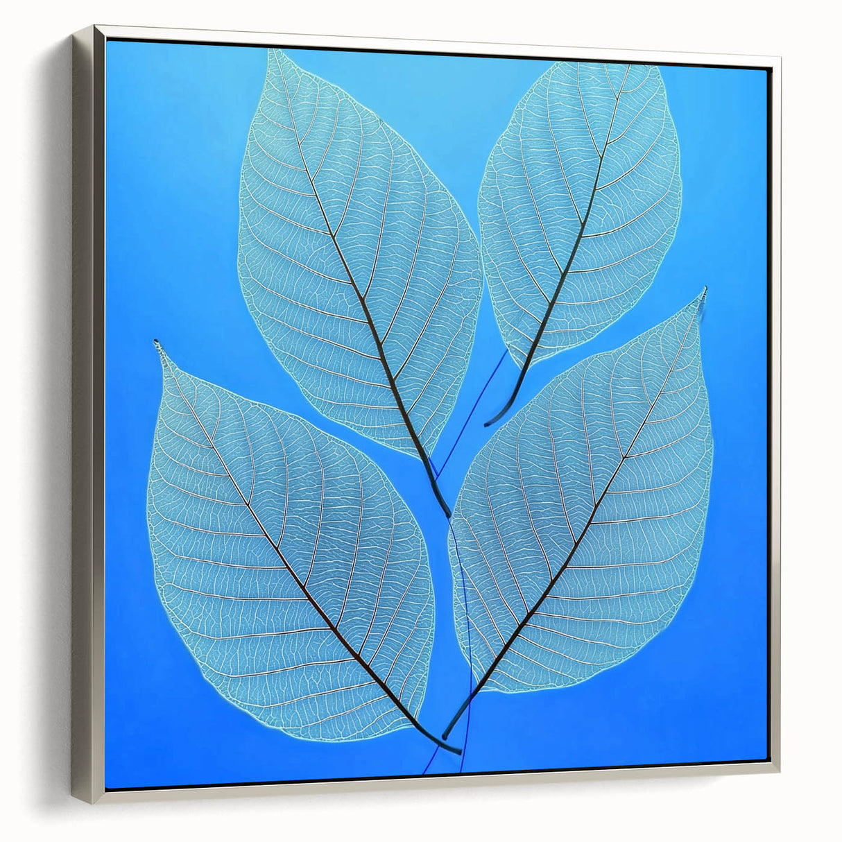 Framed canvas featuring a close-up of green leaves, set in a silver frame.