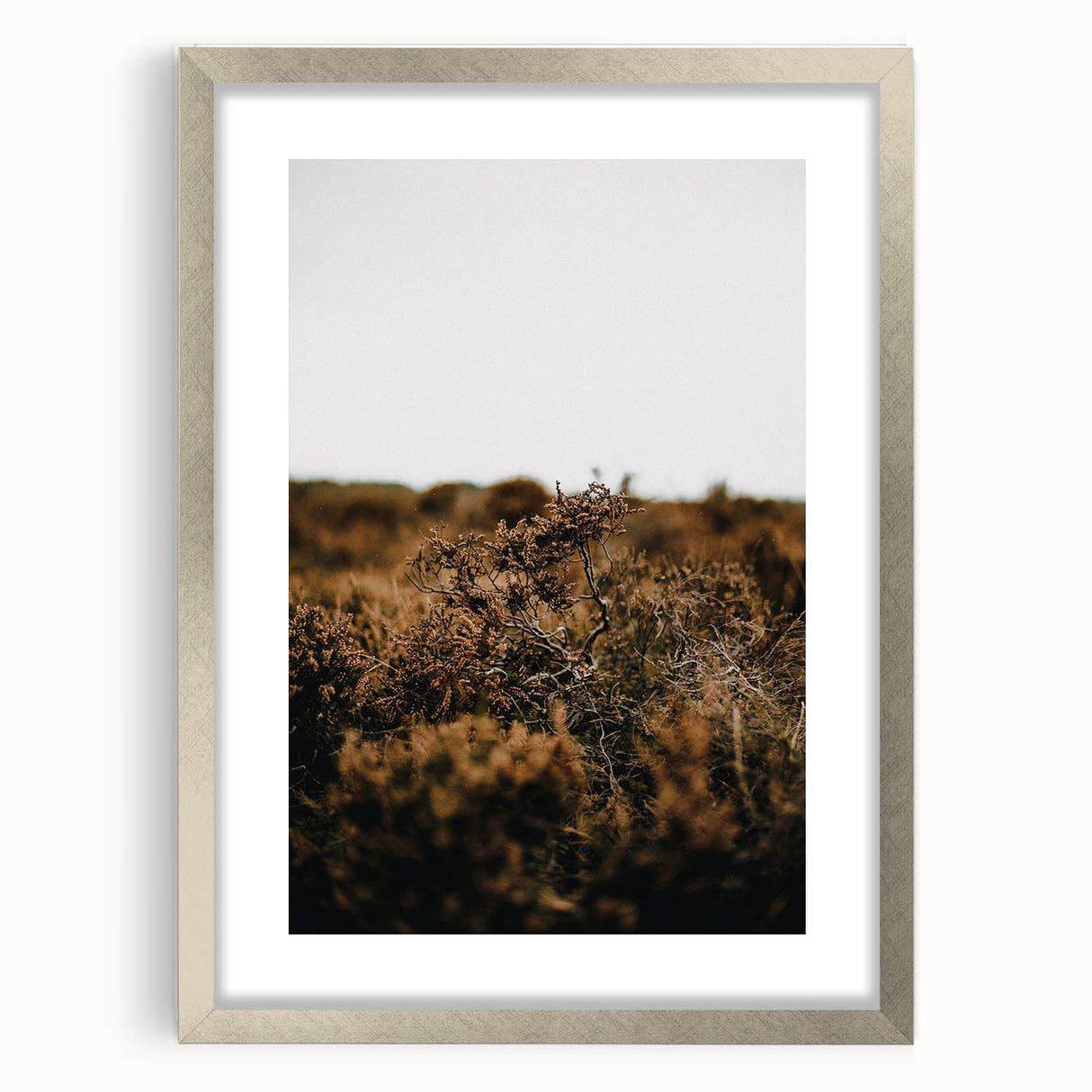 Textured abstract art print in warm autumn hues on a silver framed canvas, suitable for bedroom decor.