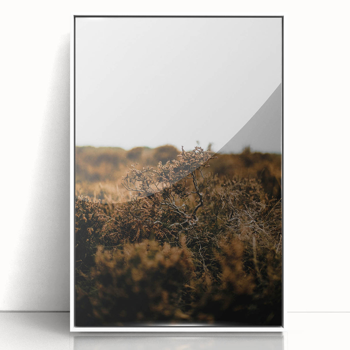 Art deco poster featuring an autumnal scene with muted orange and brown tones on a white acrylic framed print.