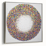 Abstract splatter art on a framed canvas with a silver border, showcasing vibrant colors and dynamic patterns, ideal for modern home decor.