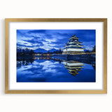 Elegant gold-framed landscape artwork depicting a majestic castle surrounded by lush greenery, presented with a white mat for a refined finish, perfect for home decor.