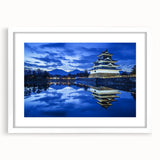 Framed landscape artwork featuring a picturesque castle set against a serene backdrop, encased in a white mat. Ideal for elegant home décor or office settings.