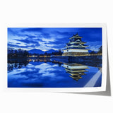 Rolled print showcasing a vibrant landscape with an intricately detailed castle, featuring lush greenery and a clear blue sky, packaged securely in a cardboard tube for safe shipping.