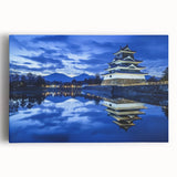 Stretched canvas artwork depicting a picturesque landscape with a majestic castle surrounded by lush greenery and a serene blue sky, perfect for home décor.