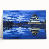 Stretched canvas artwork depicting a serene landscape with a majestic castle nestled among lush green hills, showcasing vibrant colors and intricate details, perfect for home decor.