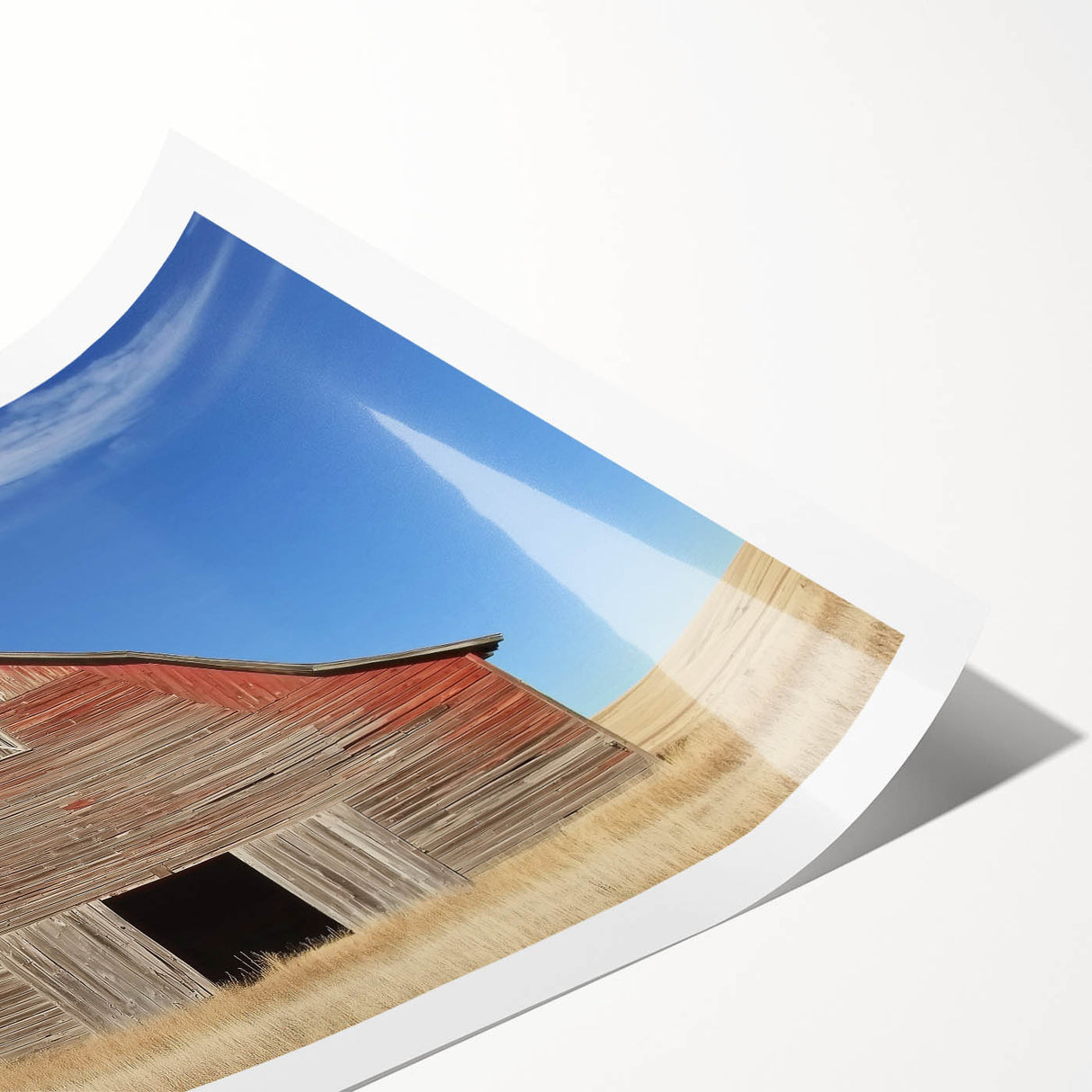 Landscape barn art print showcasing a rustic red barn surrounded by vibrant green fields, rolled and packaged in a protective tube for shipping. Perfect for home decor.