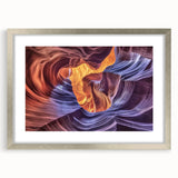 Framed landscape artwork depicting vibrant canyons in rich earth tones, showcased in a sleek silver frame with a white mat, perfect for home decor.