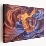 Stretched canvas artwork depicting a vibrant landscape of canyons in rich earth tones, showcasing dramatic rock formations under a clear blue sky, ideal for enhancing home decor.