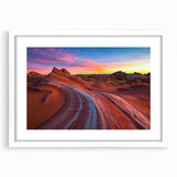 Framed desert landscape artwork featuring vibrant hues of orange and brown, elegantly matted in white, showcasing a serene view perfect for home decor.
