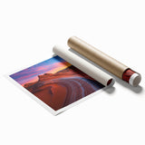 Desert landscape rolled canvas print showcasing vibrant orange and yellow hues of a sunset over sandy dunes, elegantly packaged in a protective cardboard tube.