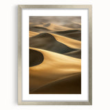 Framed landscape artwork showcasing serene sand dunes in soft beige and gold tones, elegantly matted and finished with a sleek silver frame, perfect for home decor.