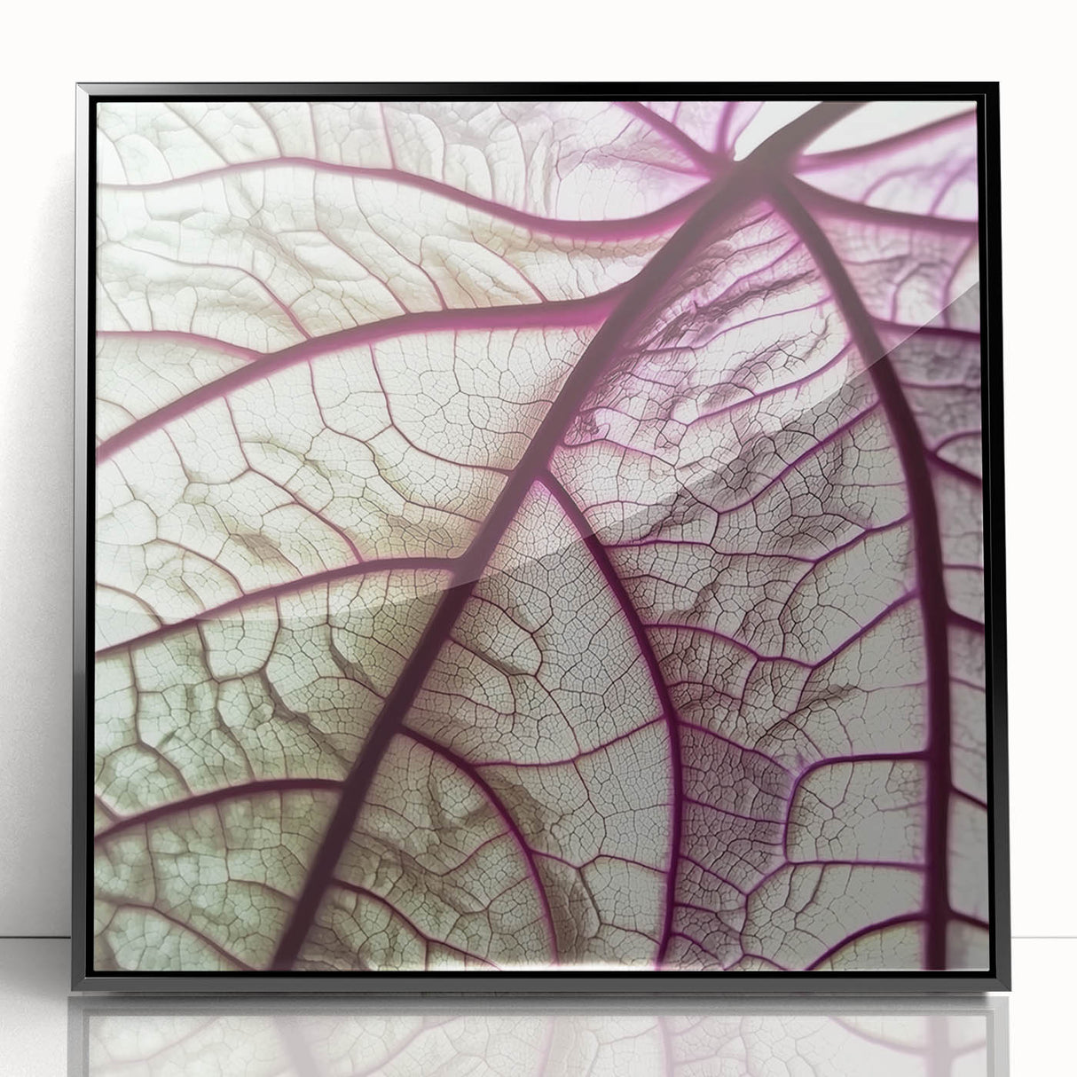 Large abstract wall art featuring close-up leaves in muted green and brown, framed in black acrylic.