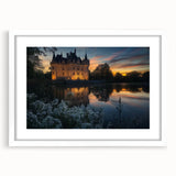 Framed landscape artwork depicting a majestic castle surrounded by lush greenery, featuring a white mat for an elegant presentation and a classic frame style.