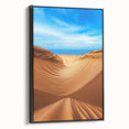 Framed canvas artwork showcasing serene desert dunes in warm earth tones, set against a black frame, perfect for modern home decor and enhancing aesthetic appeal.