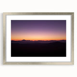 Framed landscape artwork depicting a serene desert scene, featuring warm tones of sand and sky, encased in a silver mat and frame, ideal for home decor.